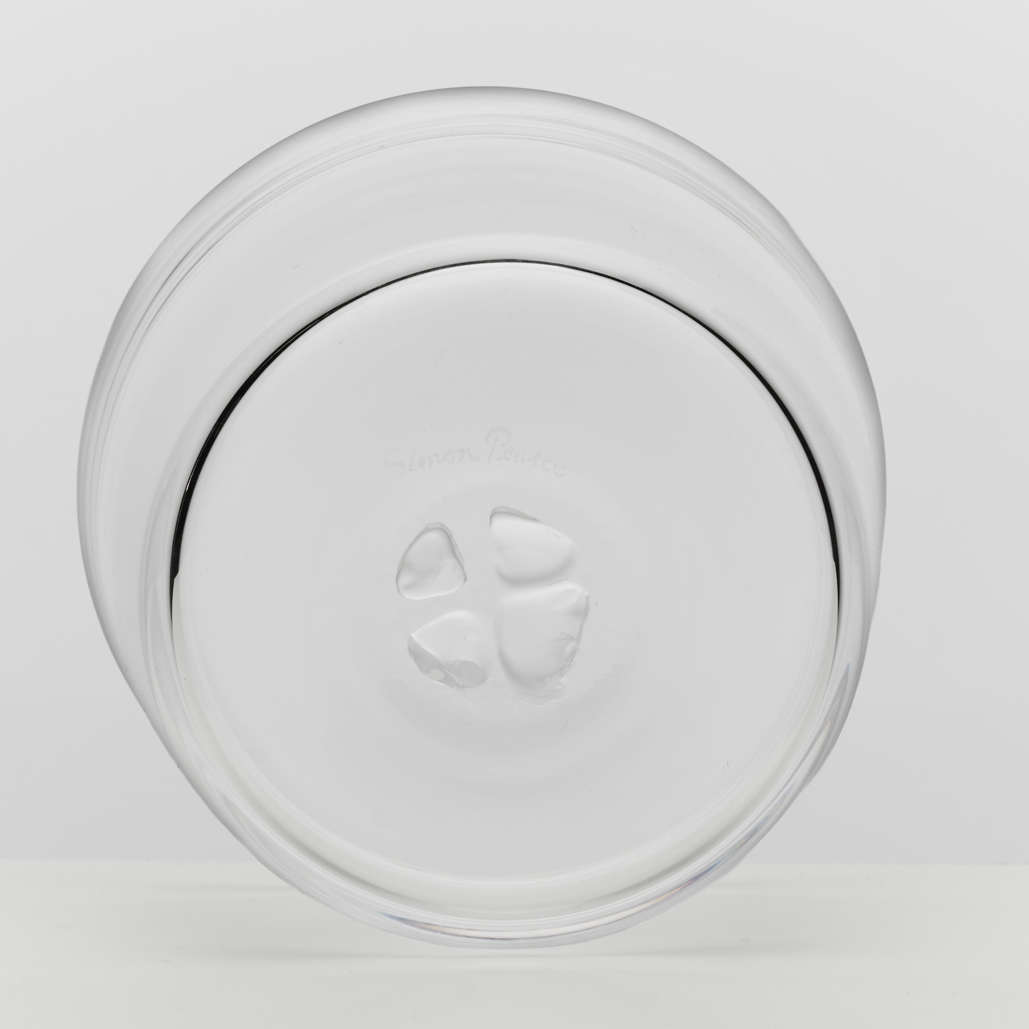 A clear glass bowl viewed from the bottom on a light gray background.