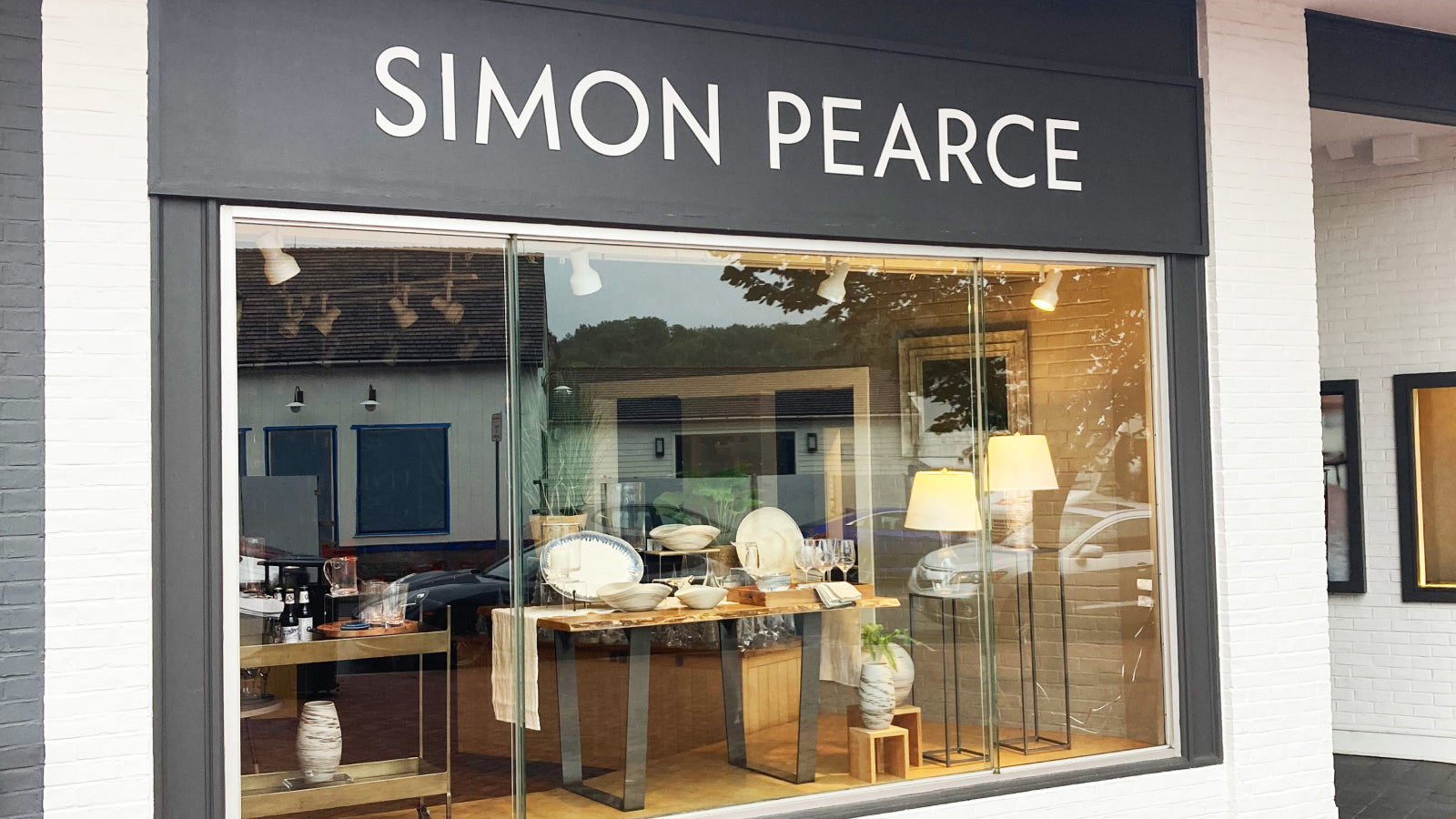 Exterior of the Simon Pearce retail store in Westport, Connecticut, featuring a dark-framed storefront with large display windows showcasing glassware, ceramics, and lamps