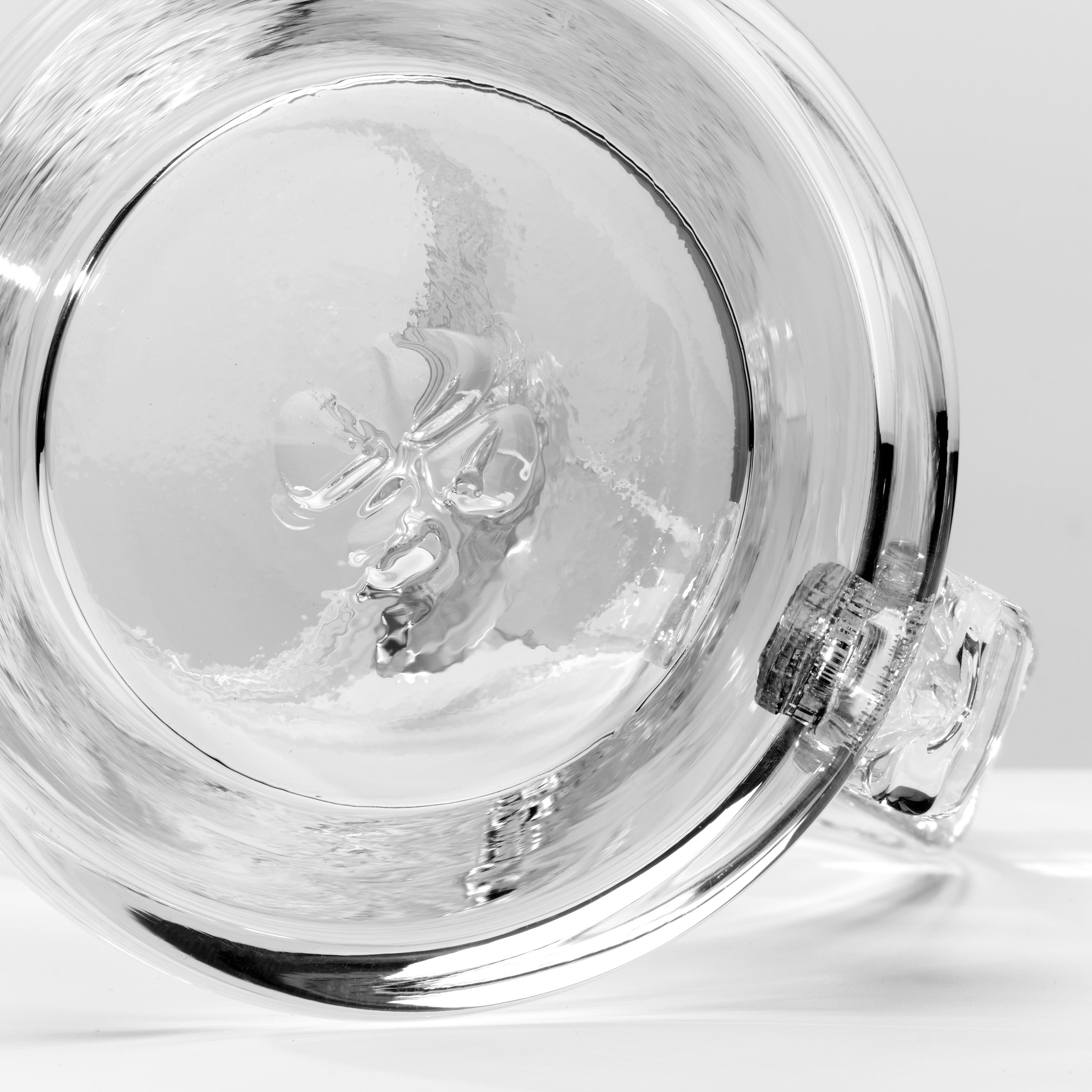 Close-up of a clear glass, photographed on a light gray background.
