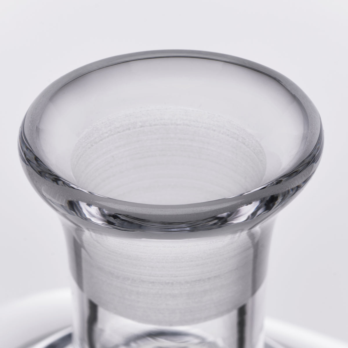 Clear glass decanter with wide flared rim and etched horizontal bands on cylindrical body.