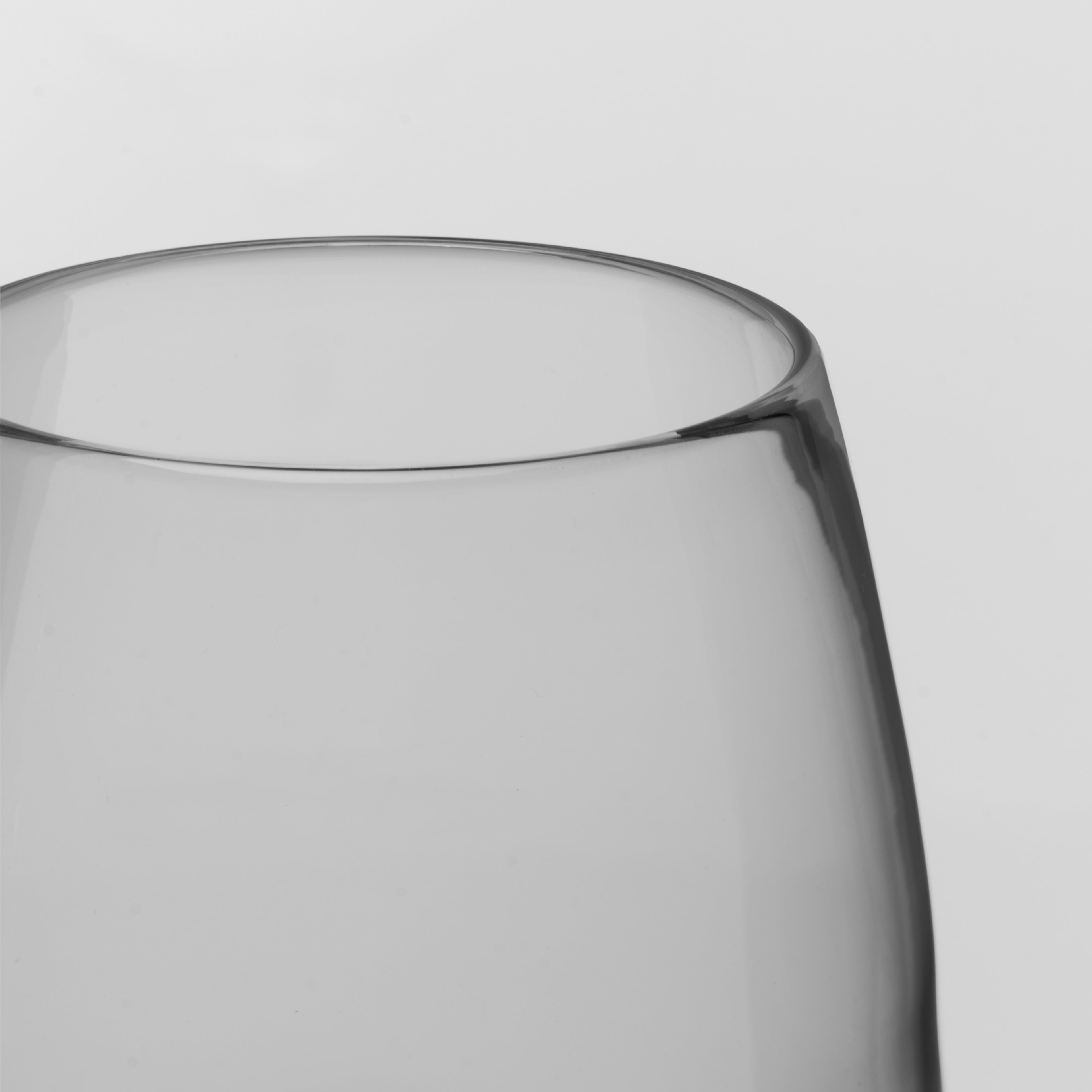 Close-up of a clear glass vessel, showing the upper curved rim and smooth transparent body against a light gray background.
