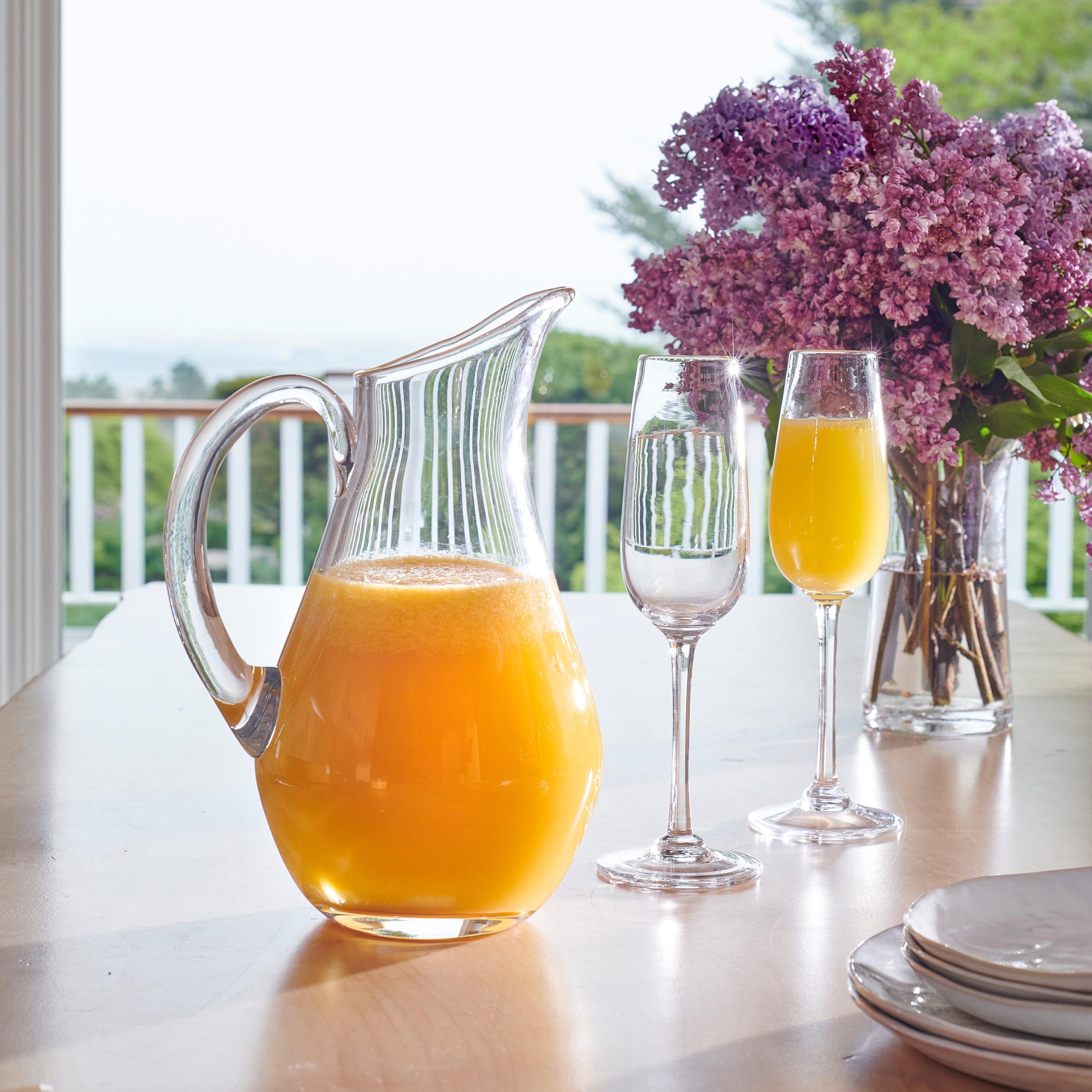 I notice this image shows a table setting with a pitcher of juice, glasses, and flowers—not flutes or a gift box as described