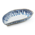 Blue and white mussel shell-shaped ceramic bowl with striped pattern interior.