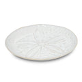 White side plate with sand dollar relief design and beige rim.