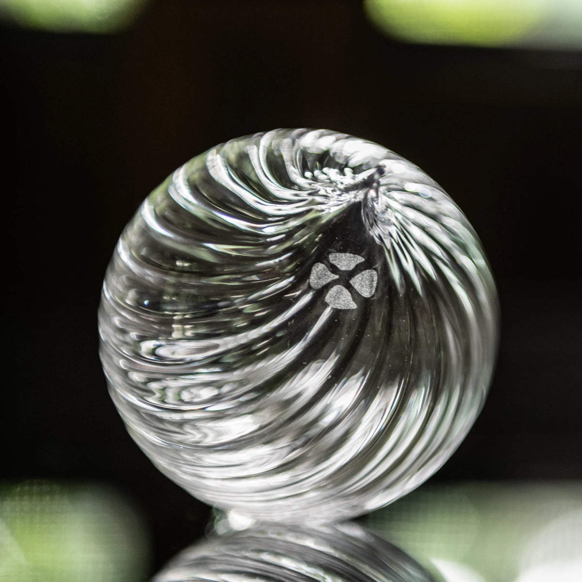 Clear glass finial ornament with swirled optic pattern and four-leaf clover design.