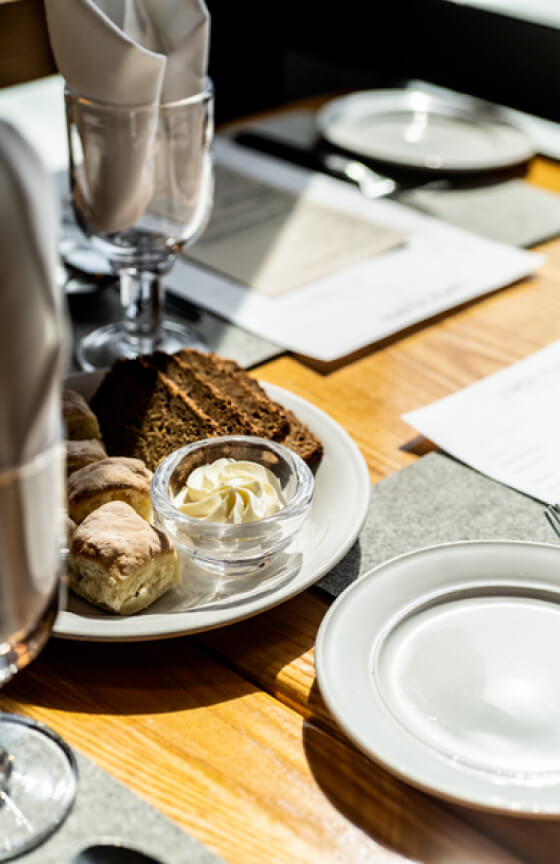 Elderly couple embracing with drinks, smiling, with a scenic backdrop.
