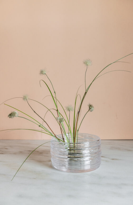 Elderly couple embracing with drinks, smiling, with a scenic backdrop.