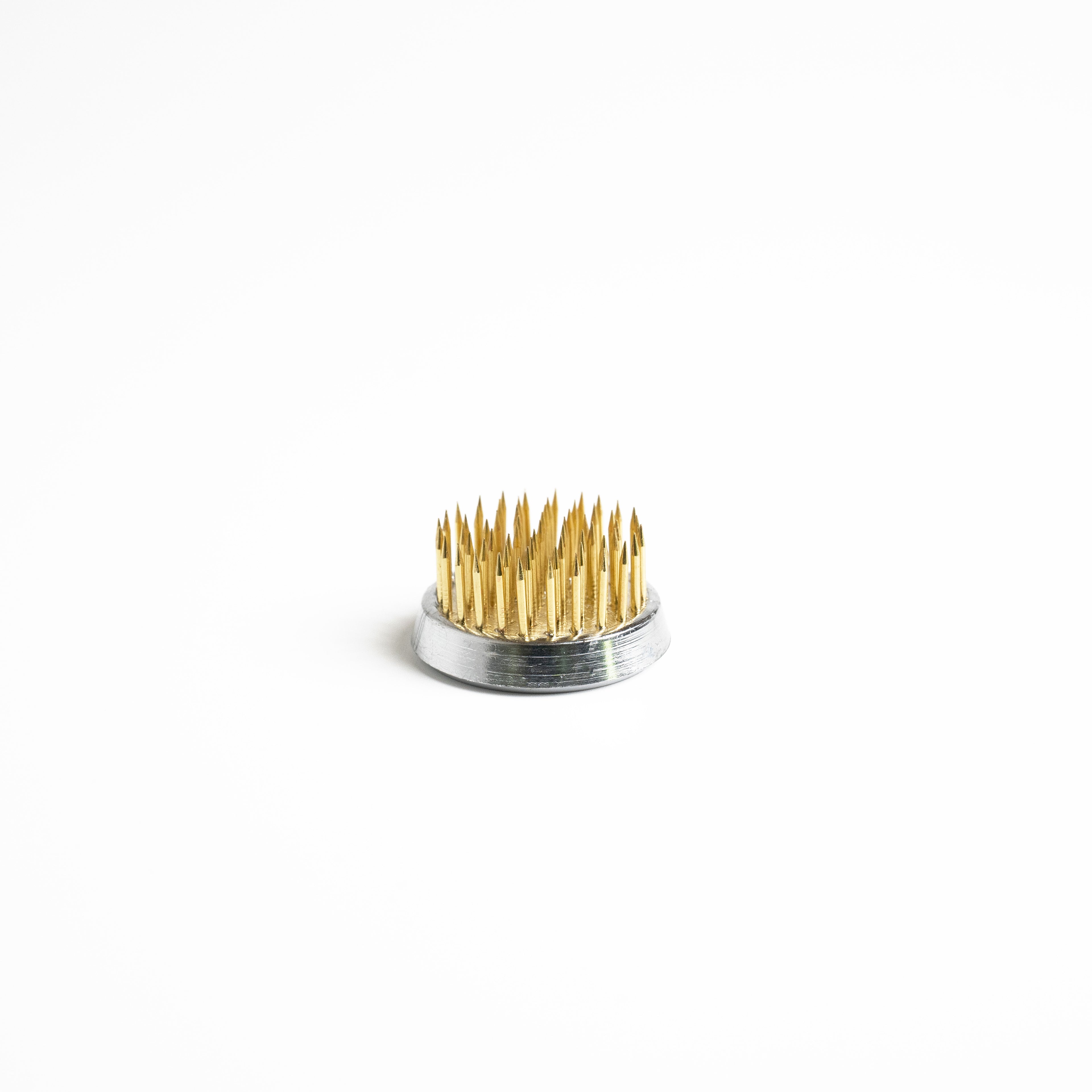 Round metal flower frog with dense golden spikes arranged in a circular pattern.