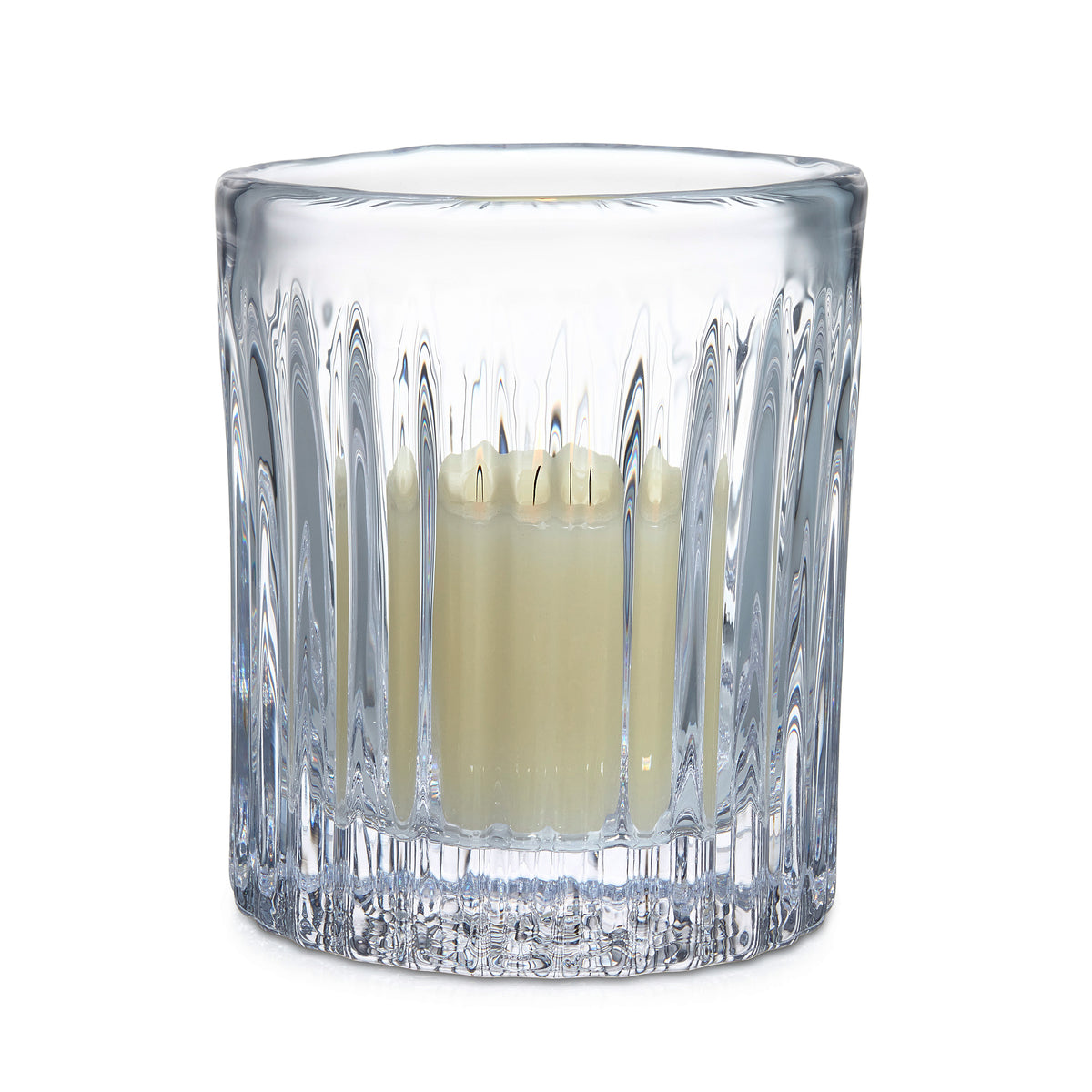 Clear crystal hurricane vase with vertical ridged pattern containing lit cream-colored pillar candle.