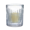 Clear crystal hurricane vase with vertical ribbed pattern holding lit cream-colored candle.