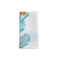 White linen napkin with teal and brown pine branch and evergreen print design.
