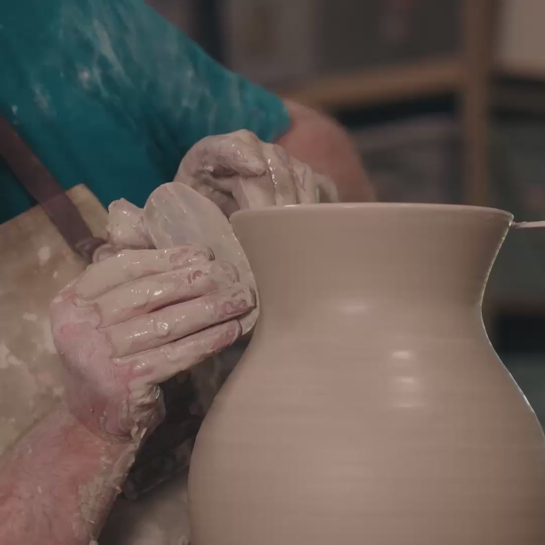 Video of one of the artisans at Simon Pearce shaping a pottery vase on a throwing wheel