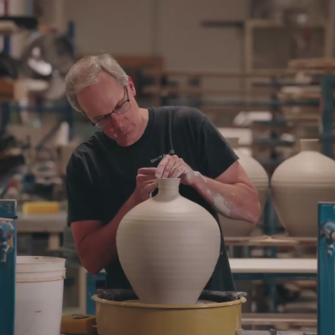 Video of one of the artisans at Simon Pearce making a pottery vase on a throwing wheel
