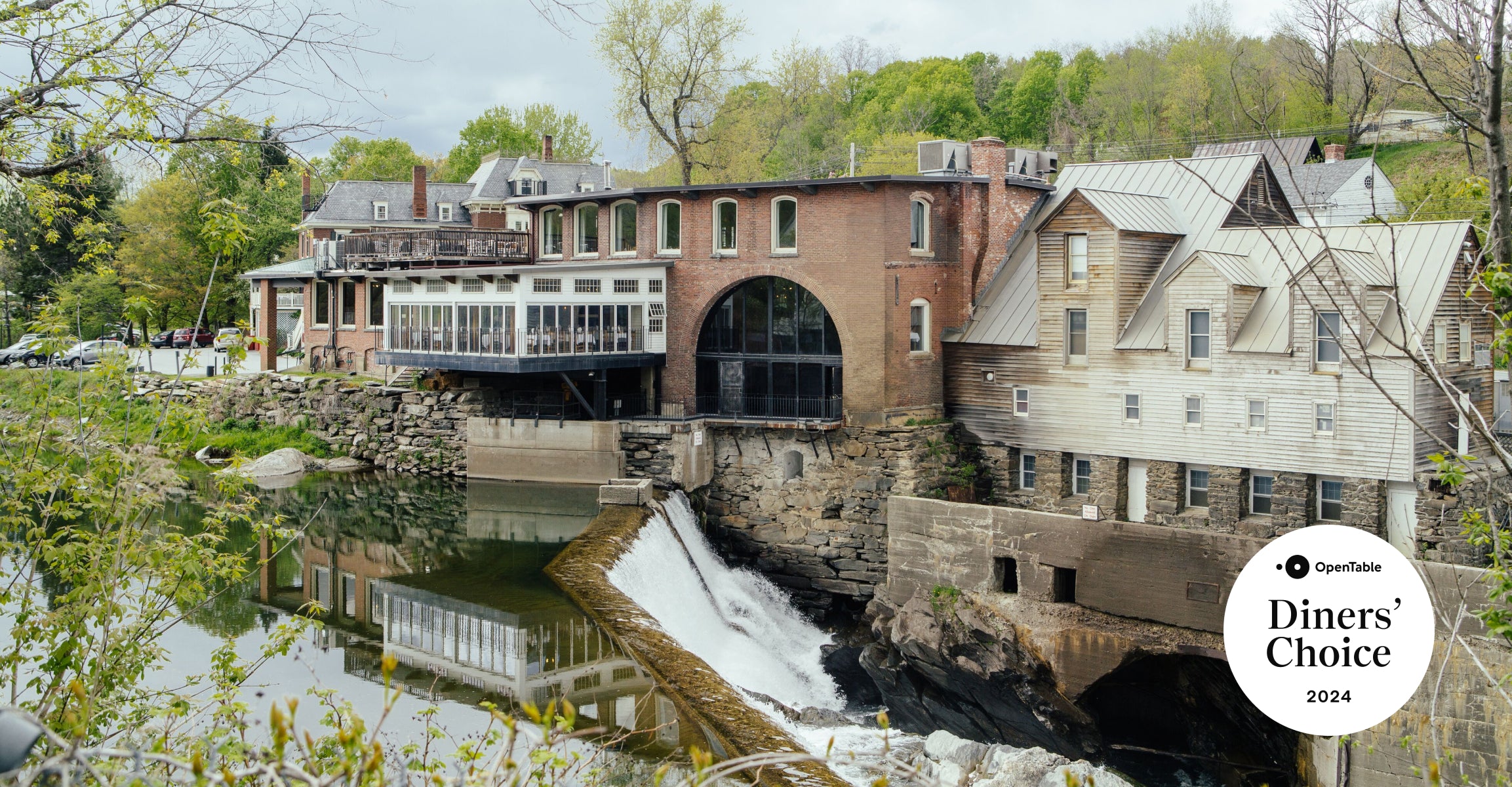 Exterior view of the Simon Pearce Restaurant at the historic Quechee Mill, with the Ottauquechee River waterfall below and an OpenTable Diners' Choice 2024 badge