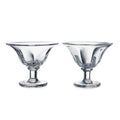 Two clear glass dessert bowls with pedestal bases and flared rims.