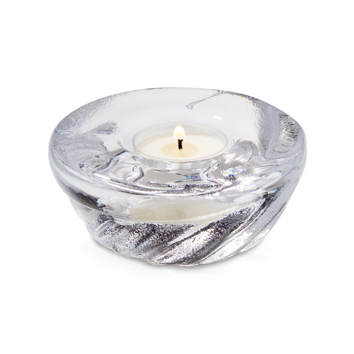 Clear glass shell-shaped tealight holder with lit white candle inside.