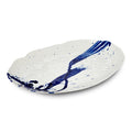 Large oval ceramic platter with cream glaze and blue brushstroke design with speckled accents.