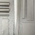 Cylindrical metal fixtures and rectangular metallic components arranged on textured gray surface.