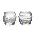 Two clear glass tealight holders with textured wrap design, each containing a small cream-colored candle.