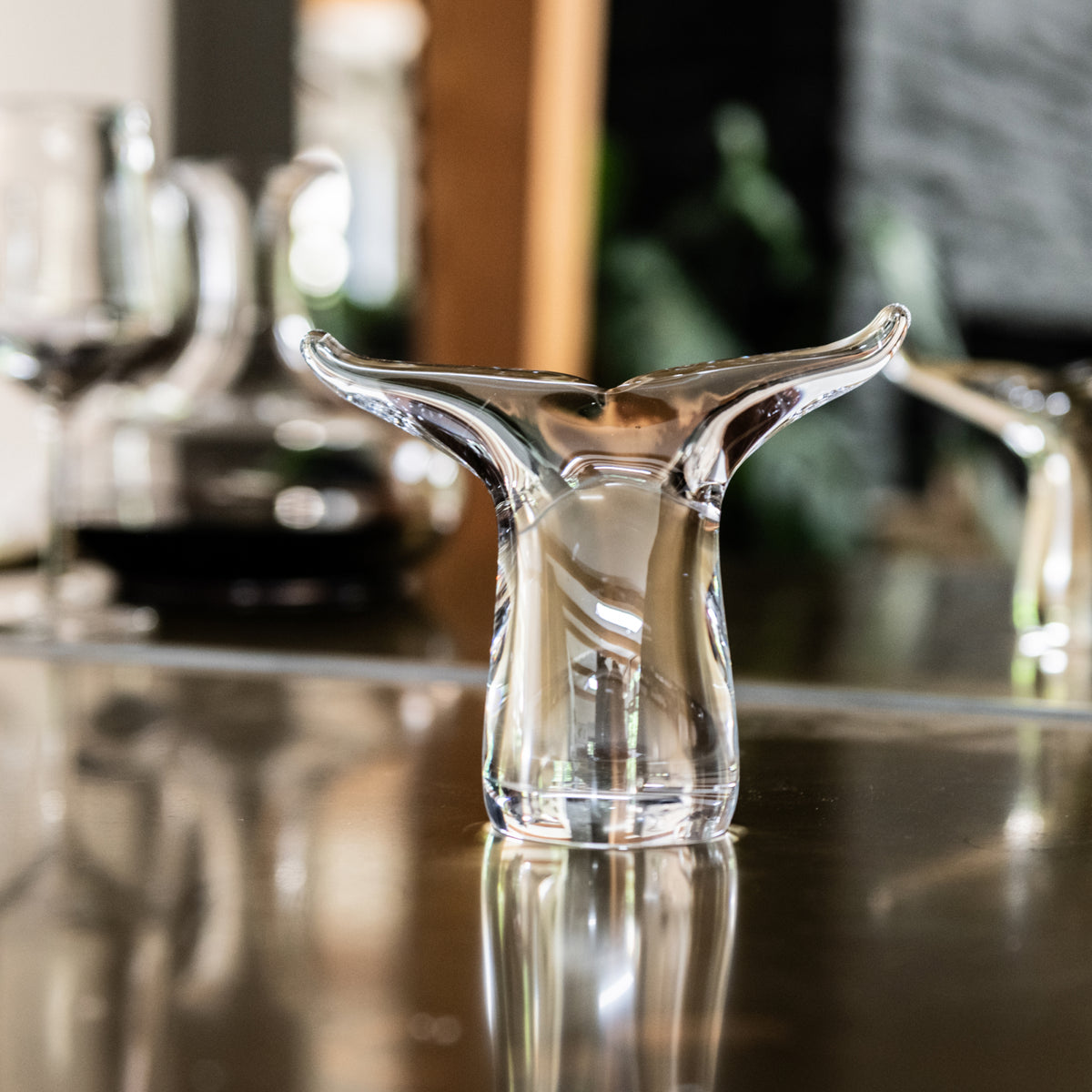Clear glass vase with two curved fins extending upward from the rim, resembling a whale tail shape.